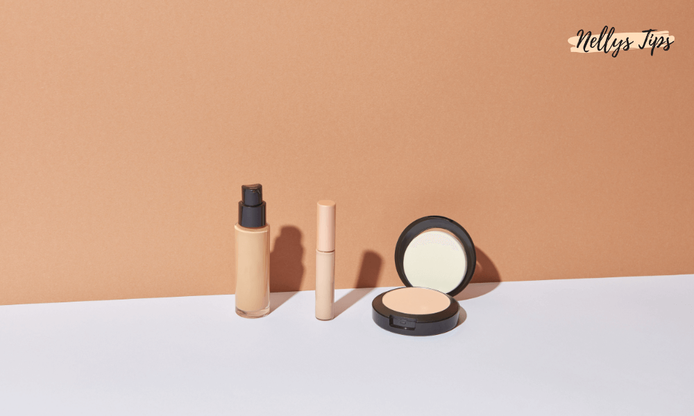 Foundation, concealer og pudder opstillet på hvid overflade med beige baggrund