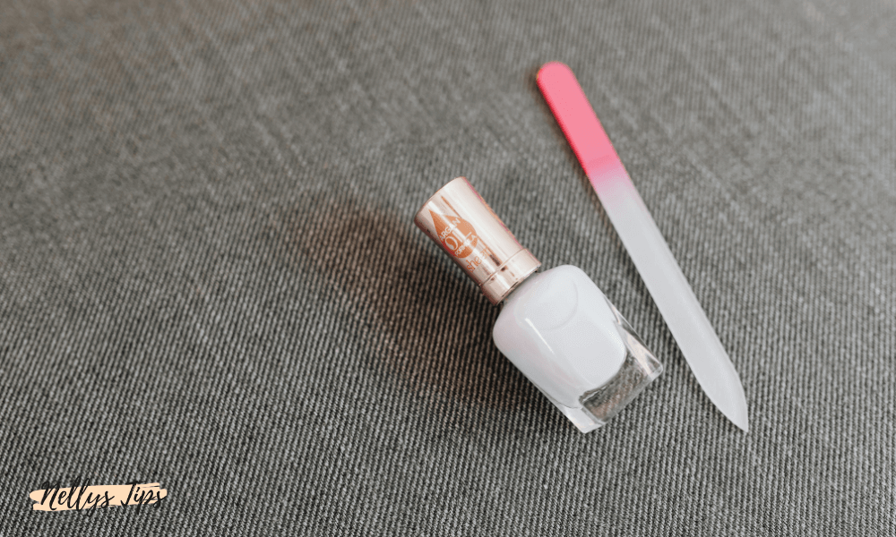 Hvid neglelak og glasneglefil med pink håndtag – klar til skånsom manicure.