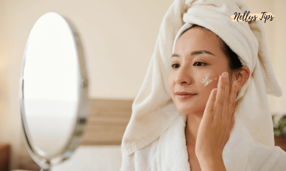 Kvinde kigger i spejlet og påfører anti-aging creme i sin hudplejerutine