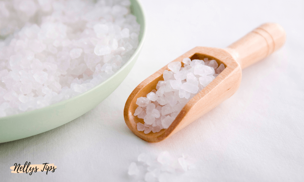 Træske og skål med groft hvidt badesalt, stilfuld wellness-opsætning.