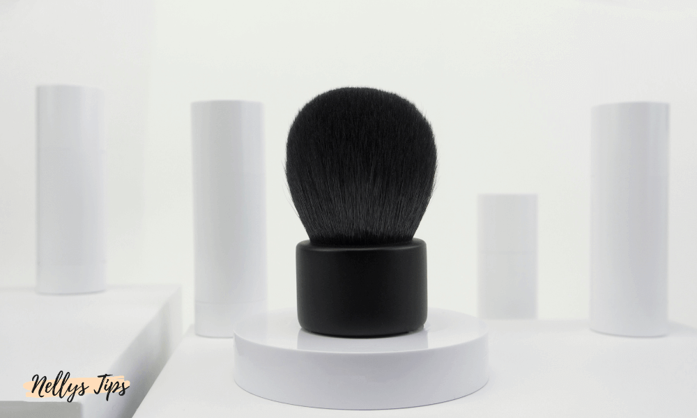 Kabuki-børste med kompakt sort skaft og tætte børstehår til jævn påføring af puder og bronzer.