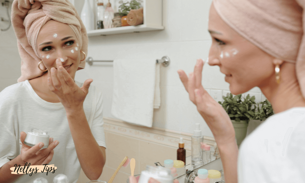 Smilende kvinde påfører øjencreme under øjet med finger for at stramme og lysne huden.