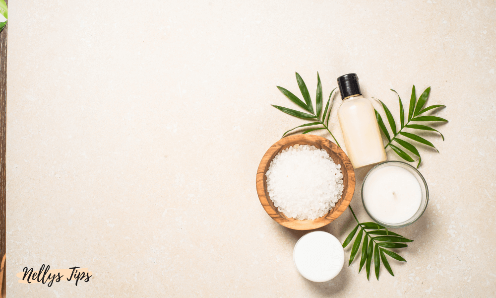 Spa-lignende fladlay med bruseprodukter, salt, stearinlys og grønne blade.