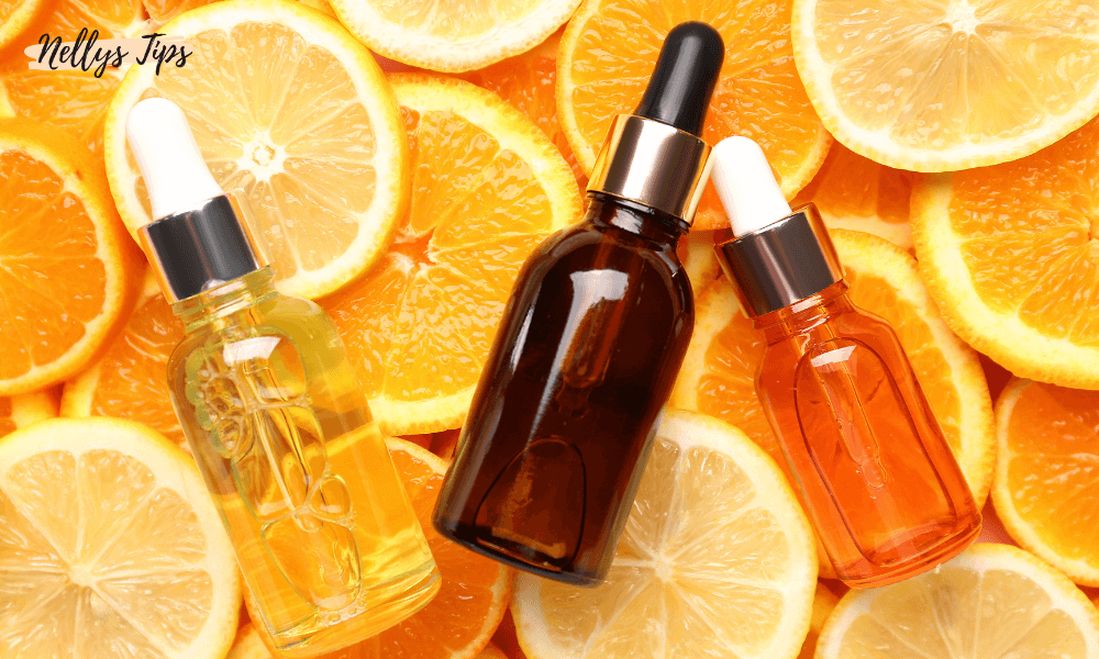 Tre dråbeflasker med C-vitamin serum placeret ovenpå friske skiver af appelsin og citron.
