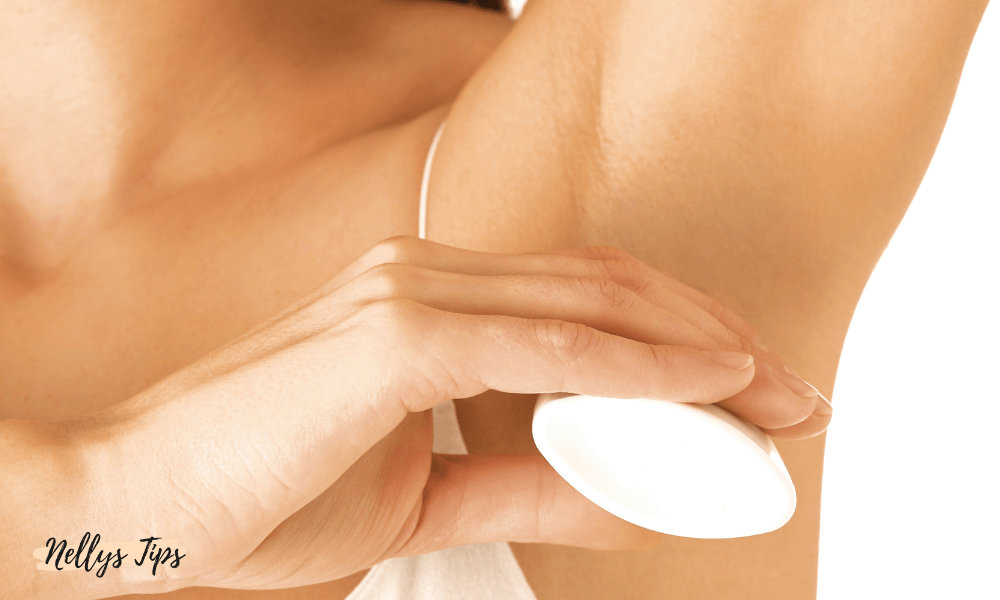 Kvinde i sportstop holder roll-on deodorant for friskhed og beskyttelse.